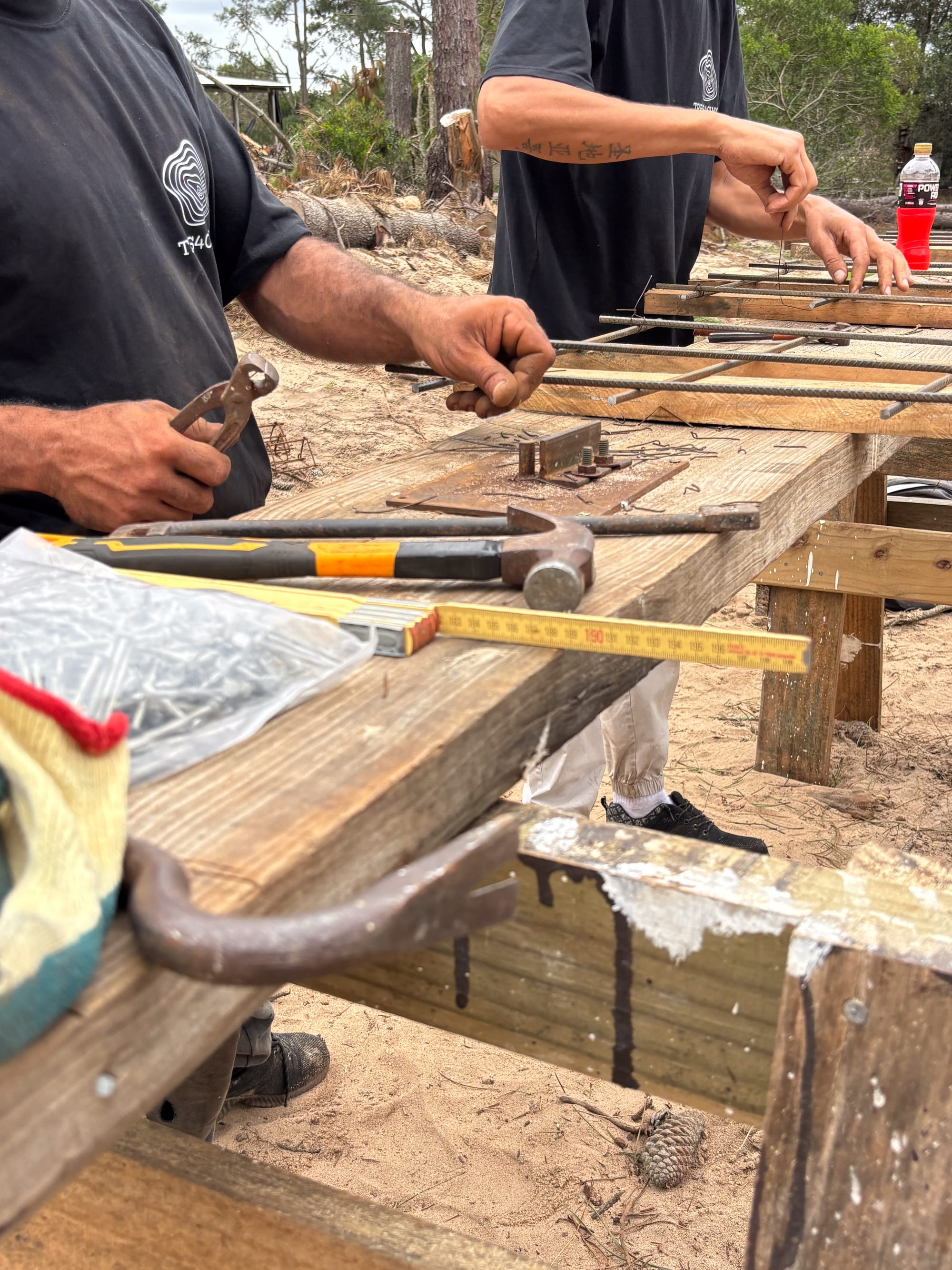 Hands with hammer and pliers over a timber beam